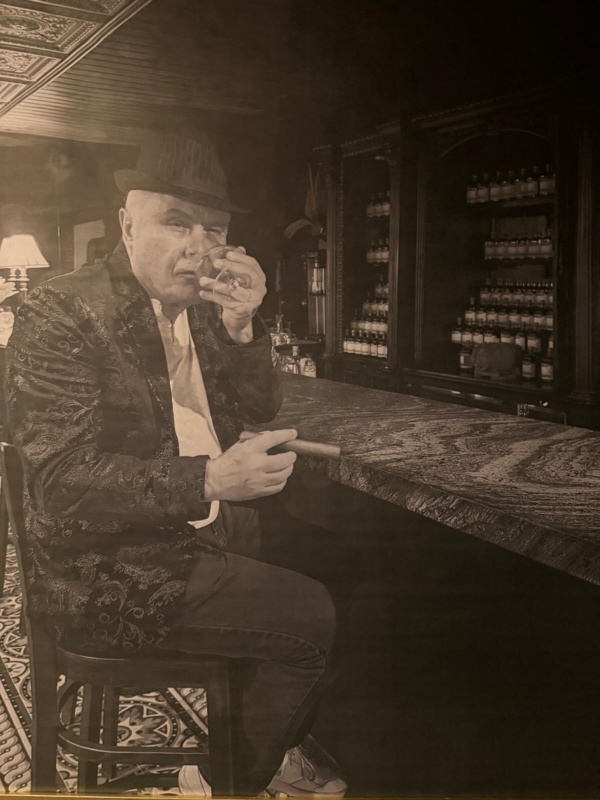 Rum Master José Pérez Cárdenas seated at the Little River bar with a glass of rum