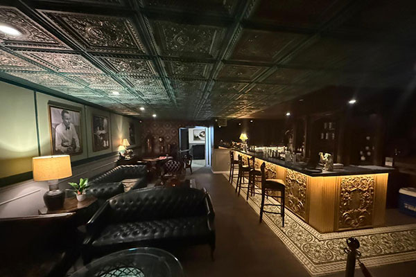 The speakeasy bar with pressed-tin ceiling and gilded counter